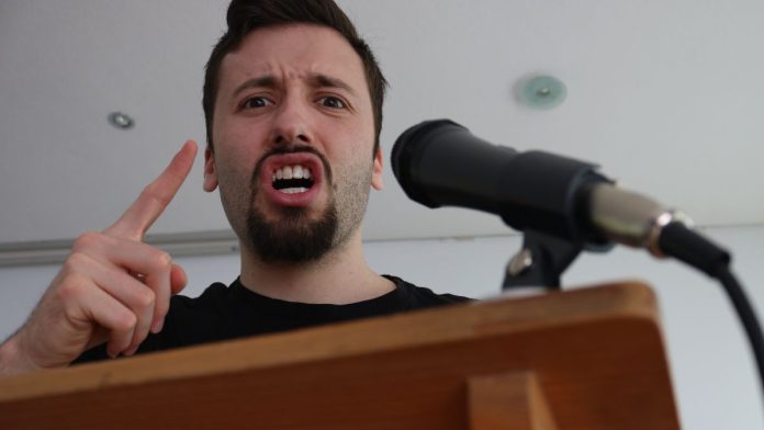 SGLA-Finds-Its-Voice,-Publicly-Blasts-States'-Sweeps-Bans Angry man speaks into microphone