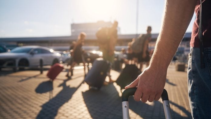 People carry their bags for a trip as WOW Vegas plans to exit Louisiana.