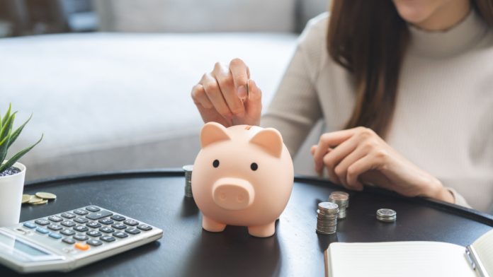 A woman puts money into a piggy bank as Xanada Investments backs a sweepstakes casino game aggregator.