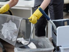 Janitor emptying office waste basket