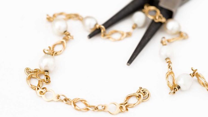 Pliars cutting up gold bracelet