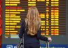 A woman looking at a board of flight departures