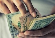 A hand of money as FanDuel received fines from Iowa's gaming regulator.