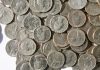 A pile of American coins as Fanatics plans to add a transaction fee to online wagers in Illinois.