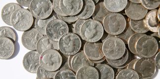 A pile of American coins as Fanatics plans to add a transaction fee to online wagers in Illinois.