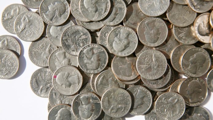 A pile of American coins as Fanatics plans to add a transaction fee to online wagers in Illinois.