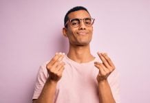 A man doing the hand gesture representing money, richness or payment