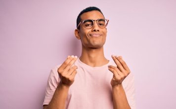 A man doing the hand gesture representing money, richness or payment