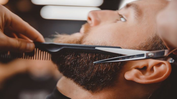 A man's beard being trimmed