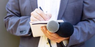 Opinion: It’s time to change up online casino legalization messaging Hand with notebook holding microphone