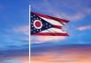 The flag of Ohio against a colourful sky
