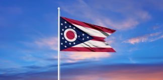 The flag of Ohio against a colourful sky
