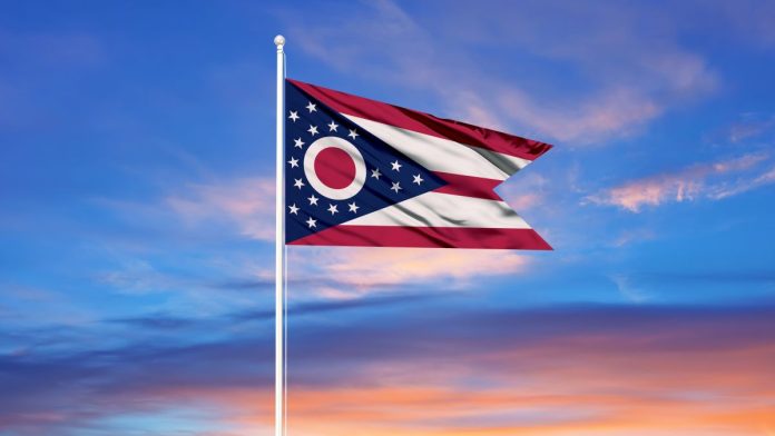 The flag of Ohio against a colourful sky