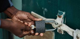 Hands locking a lock