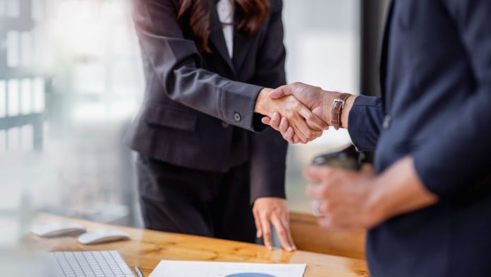 Two people shaking hands on a business deal