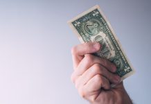 A man brandishing a one-dollar bill