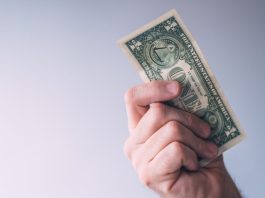 A man brandishing a one-dollar bill