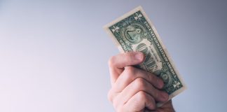 A man brandishing a one-dollar bill