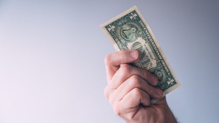 A man brandishing a one-dollar bill
