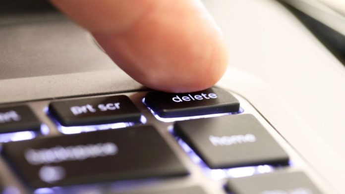 A person hitting a 'delete' button
