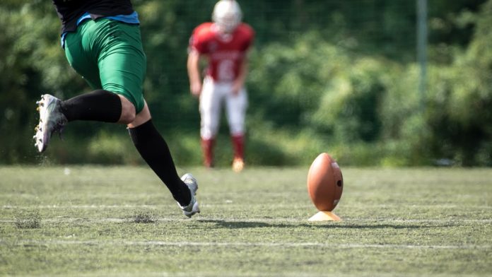 A player kicks a football as the owner of VGW deals with backlash due to a casino brand.
