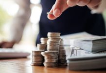 A person stacking dollar bills and counting coins