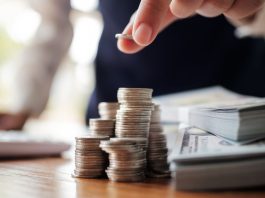 A person stacking dollar bills and counting coins
