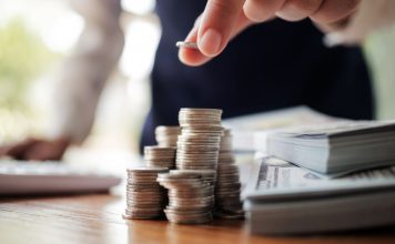 A person stacking dollar bills and counting coins