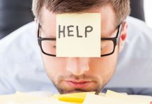 A man when a sticky note on his forehead asking for help