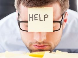 A man when a sticky note on his forehead asking for help