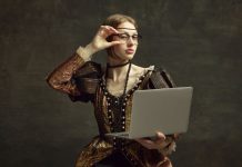 An aristocratic-looking woman holds a laptop