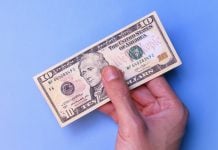 Circa Sports implements $10 minimum bet in Illinois after tax change A person's hand holding an American $10 bill