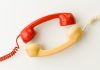 NCPG files for arbitration to resolve 1-800-GAMBLER hotline dispute Two wired telephone receivers facing each other