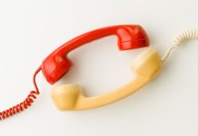 Two wired telephone receivers facing each other