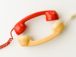 Two wired telephone receivers facing each other