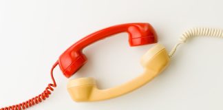 Two wired telephone receivers facing each other