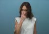 A woman doing an "I'm watching you" gesture to camera