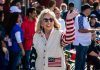 Rep. Dina Titus waves while wearing clothing adorned with the U.S. flag