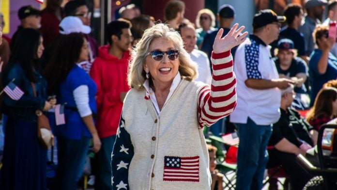 Titus-tacks-FAIR-BET-Act-onto-2026-national-defense-bill Rep. Dina Titus waves while wearing clothing adorned with the U.S. flag