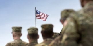 Senators pushing for funding for military gambling addiction research U.S. army personnel facing a flying American flag