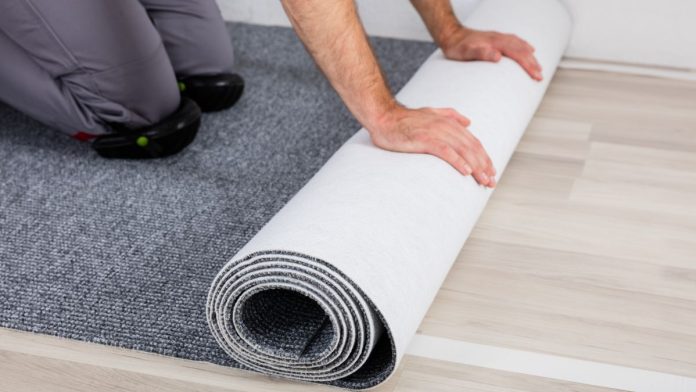 Caesars-Sportsbook-rolls-out-'exhaustive'-NFL-live-betting-with-Kero-Sports A person rolling out new carpet onto a hard wood floor