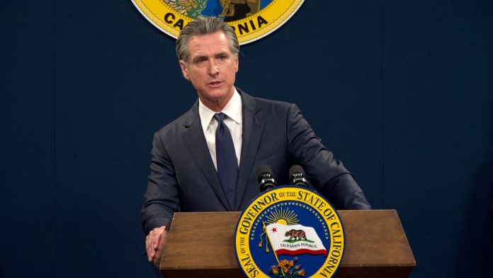 California-passes-sweeps-ban,-sends-it-to-Gov.-Newsom's-desk California Gov. Gavin Newsom stands at a podium with the seal of California in the background