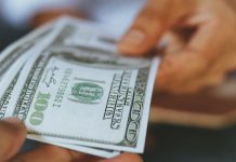 A person handing over money, as if to the taxman