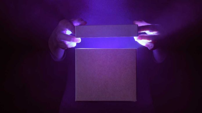 Hands opening a glowing box