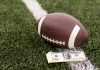 Kalshi trading volume soars far above $400M in NFL Week 1 An NFL football lying on a football field next to a stack of U.S. banknotes