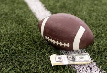 Kalshi trading volume soars far above $400M in NFL Week 1 An NFL football lying on a football field next to a stack of U.S. banknotes