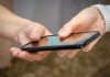 NJ court orders NCPG to cease using 1-800-GAMBLER helpline A person handing over a phone to another person