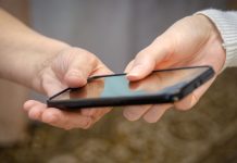 NJ court orders NCPG to cease using 1-800-GAMBLER helpline A person handing over a phone to another person