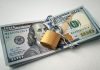 A stack of 100 dollar bills padlocked