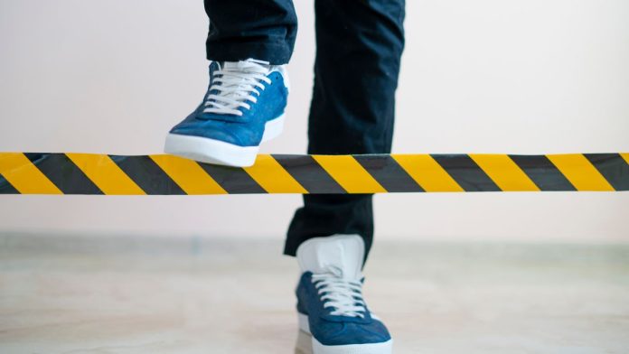 New-York-lawmaker-proposes-banning-sportsbooks-from-limiting-sharps A person stepping over a barrier intended to limit their movement
